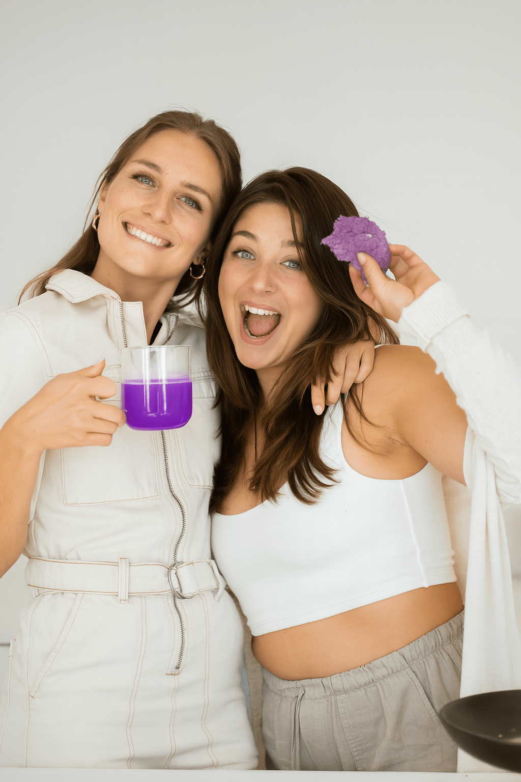 vrouwen houden lachend een ube thee en ube koekje vast