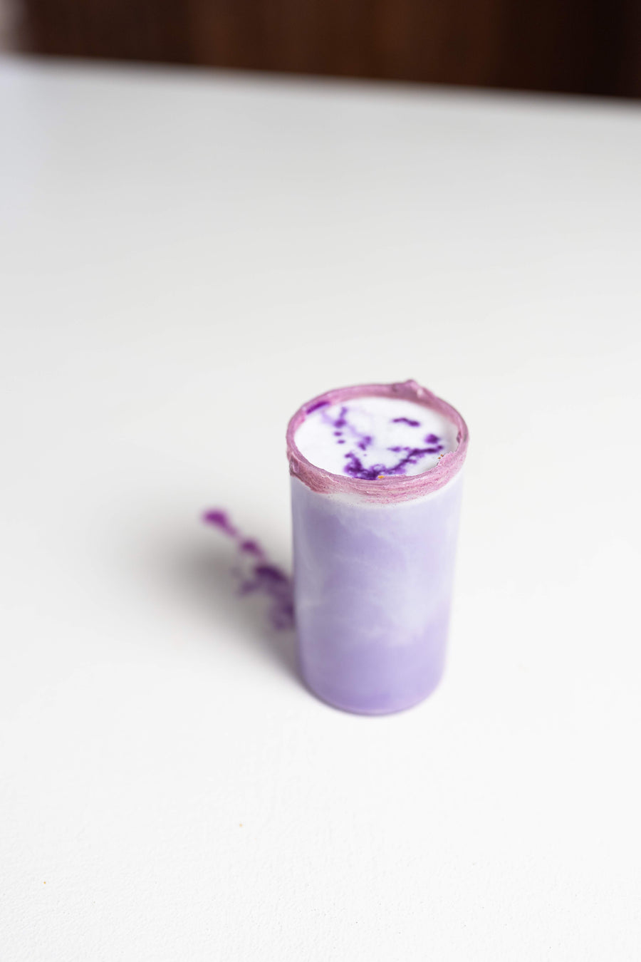 Geschichtetes Getränk mit lila Ube und Eis im Glas