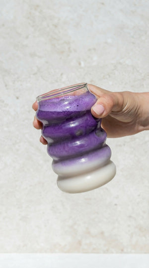 Ube latte in een glas in de hand
