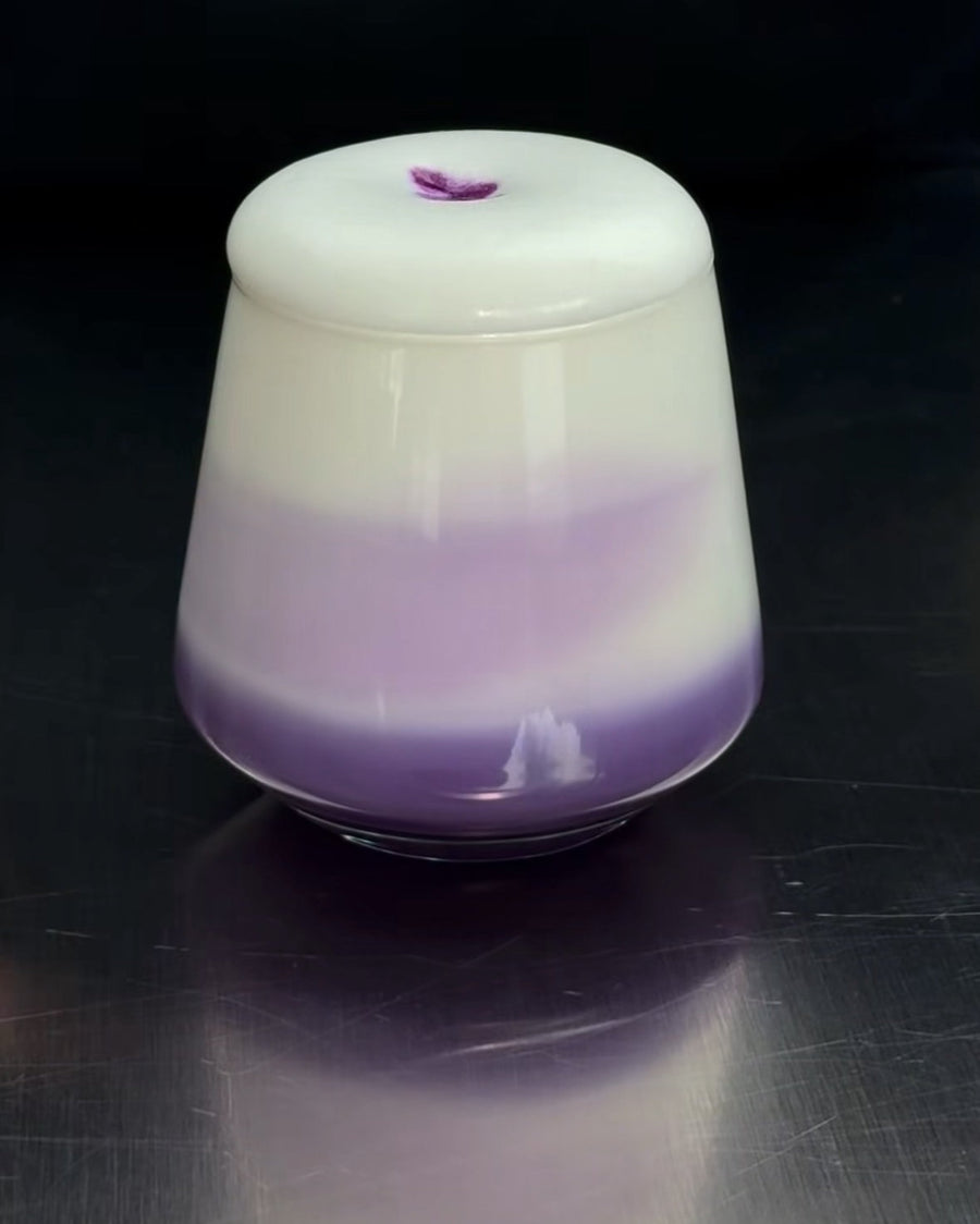 Ube cold foam: thick layer of white foam with ube on a purple-white latte in a glass