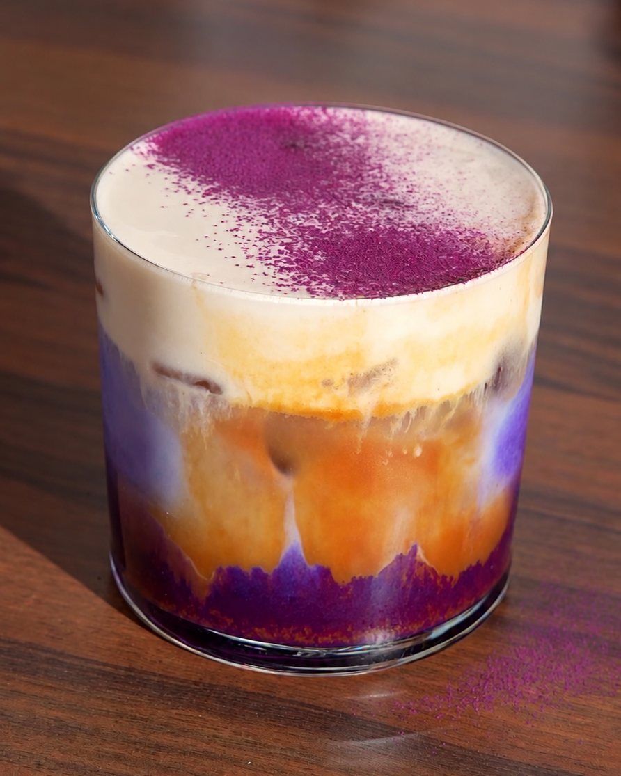 Geschichteter Ube Kaffee: lila Ube unten, darüber Espresso und Milchschaum mit Ube-Pulver